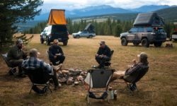 A truck parked on BLM public lands with a sign indicating new dispersed camping rules for 2026.