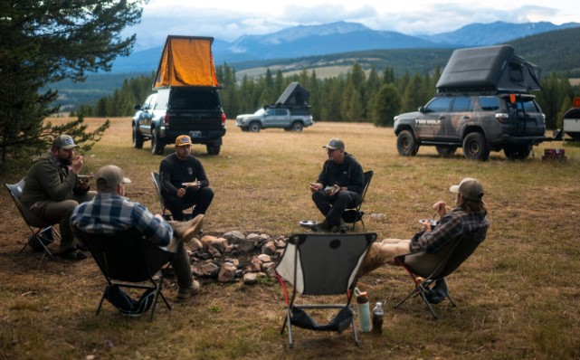 A truck parked on BLM public lands with a sign indicating new dispersed camping rules for 2026.