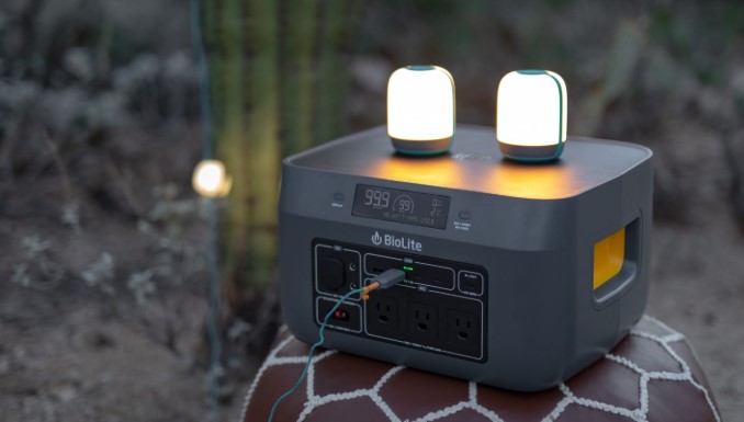 A high-quality portable power station charging devices on the tailgate of a camping truck.