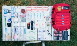 A comprehensive overlanding first aid and trauma kit opened on the tailgate of an off-road truck.
