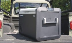 A Dometic 12V camping fridge sliding out of a custom truck bed drawer system.