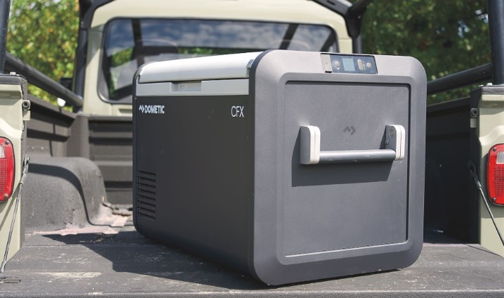 A Dometic 12V camping fridge sliding out of a custom truck bed drawer system.